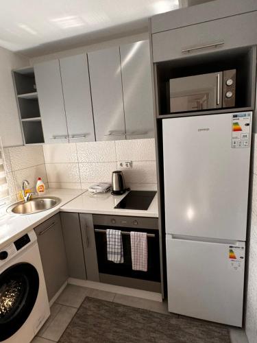 a small kitchen with a refrigerator and a sink at Guest House deluxe in Orašje