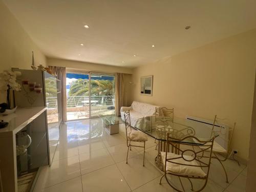 un salon avec une table en verre et des chaises dans l'établissement Sea view Croisette, à Cannes