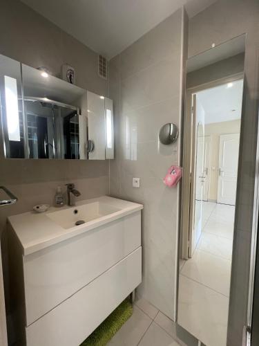une salle de bain blanche avec un lavabo et un miroir dans l'établissement Sea view Croisette, à Cannes