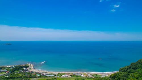 a view of the ocean from a hill at 【南房テラス】180度パノラマオーシャンビュー絶景を楽しむリゾート別荘の家 in Kanaya