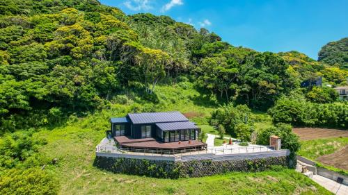an aerial view of a house on a hill at 【南房テラス】180度パノラマオーシャンビュー絶景を楽しむリゾート別荘の家 in Kanaya