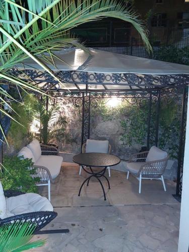 a patio with a table and chairs under a gazebo at Luxury Apartman ZOGAN in Opatija