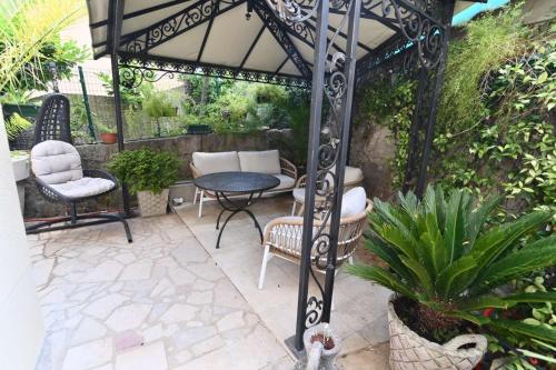 a patio with a gazebo with chairs and a table at Luxury Apartman ZOGAN in Opatija