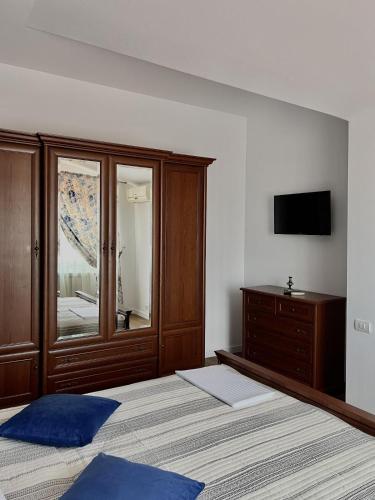 a bedroom with a bed and a dresser with a television at Marsali Vila in Constanţa