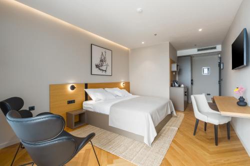 a hotel room with a bed and a desk and a chair at Hotel Squero in Rovinj