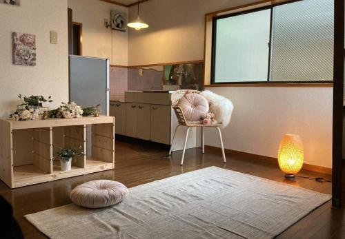 Una habitación con una cocina con una silla y una ventana. en コテージ上浦, en Azamui