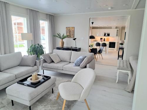 ein Wohnzimmer mit Sofa, Stühlen und einem Tisch in der Unterkunft Villa Alicia, oma 85 m2 talo, ilmastointi in Kokkola