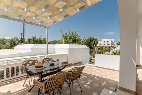 a patio with a table and chairs on a balcony at Birikos Hotel & Suites in Agios Prokopios