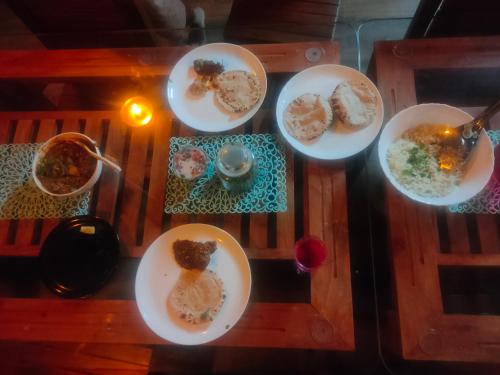 a group of plates of food on a table at Dhara Dhvani Getaway Homes in Tindummal