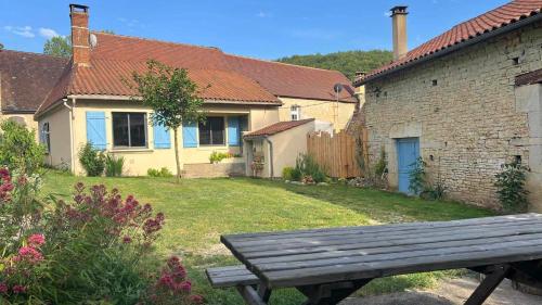 a wooden bench sitting in front of a house at Maison de village avec jardin clos in Bouzic