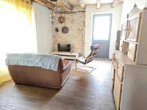 a bedroom with a couch and a chair in a room at Maison de village avec jardin clos in Bouzic