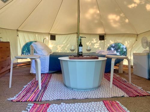 a tent with a tub and a bottle of wine at Glamping de Cerveira in Vila Nova de Cerveira