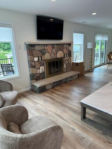 a living room with a stone fireplace with a flat screen tv at Lakeview Hills Golf & Resort in Lexington