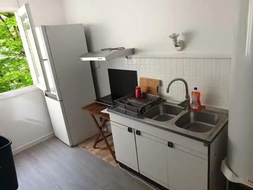 une petite cuisine avec un évier et un réfrigérateur dans l'établissement SleepSmartParisRERA5Min, à Boissy-Saint-Léger