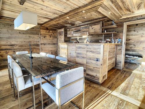 a kitchen with wooden walls and a wooden table and chairs at Crans-Montana Luxe & Charme Appartement - Ski in & Out in Crans-Montana