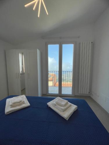 a bedroom with a blue bed with two towels on it at Pollina Suites & Apartments in Pollina