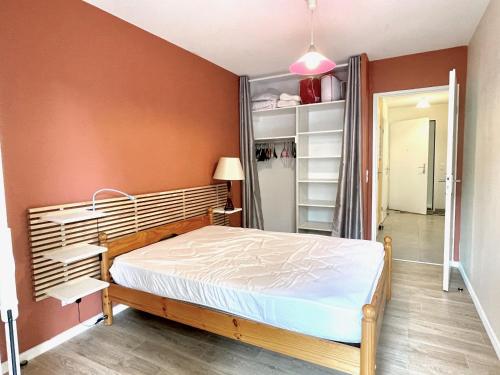 - une chambre avec un lit et un mur orange dans l'établissement ACARimmo, à Vieux-Boucau-les-Bains