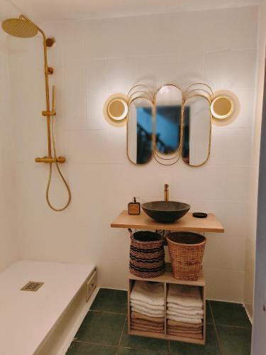 une salle de bain avec un lavabo et des miroirs au mur dans l'établissement Suite familiale 