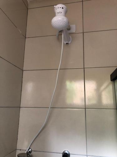 a shower head with a cord hanging from a wall at POUSADA EIRU in Bonito