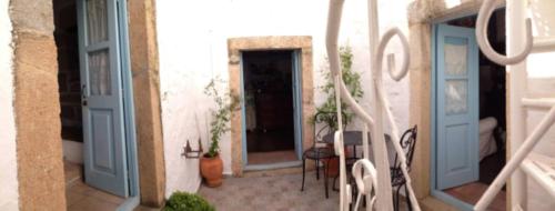 a hallway with blue doors and a table and chairs at Patmos Chora with a View in Patmos
