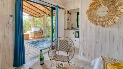 Cette chambre dispose d'une table, d'une chaise et d'une baignoire. dans l'établissement Cabanes Trésors de Campagne,spas privatifs, à Villarzel-du-Razès