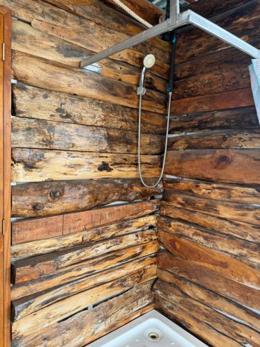a room with a wooden wall with a shower at Watyai GuestHouse in Samut Songkhram