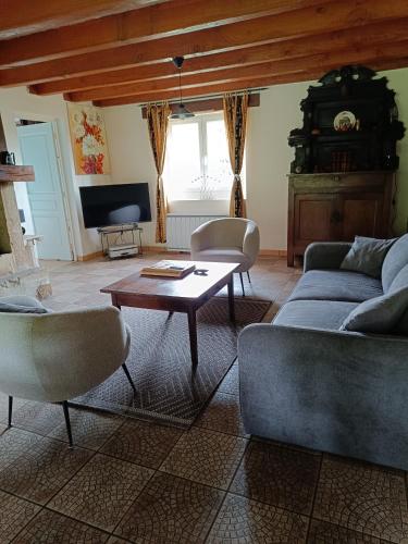 un salon avec un canapé et une table dans l'établissement Grand gîte deTranset, à Thauron