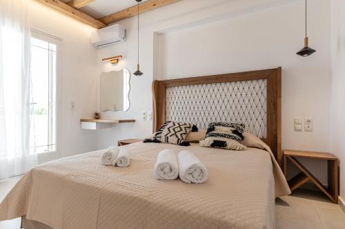 a bedroom with a bed with two towels on it at Birikos Hotel & Suites in Agios Prokopios