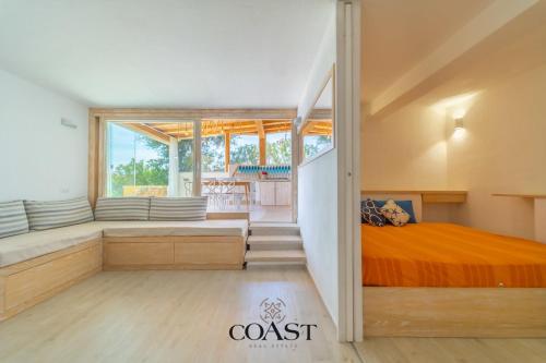 Un dormitorio con una cama y una ventana grande. en Appartamento Smeraldo - Con vista mare, en Olbia