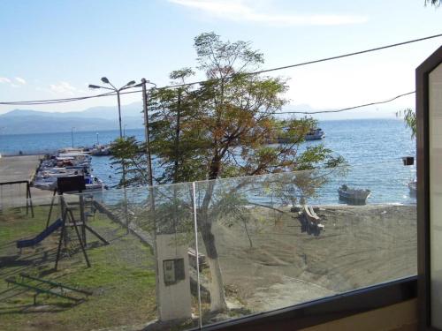 a view of the ocean from a window with a tree at Filippos Apartments in Amarinthos