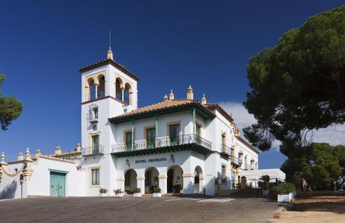 un edificio blanco con una torre de reloj en la parte superior en Hotel Oromana, en Alcalá de Guadaira