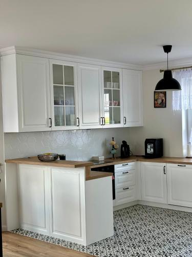 a kitchen with white cabinets and a counter top at Dworek pod Krzyżtoporem Ujazd Agroturystyka- pokoje do wynajęcia in Iwaniska