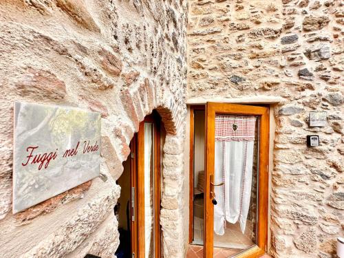 a facade of a stone building with a sign that reads fresh and lived at Hostdomus - Fuggi nel Verde in Finale Ligure