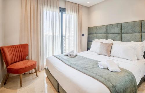 a bedroom with a large bed and a chair at AS Premium By Soho Hotels Maarif in Casablanca