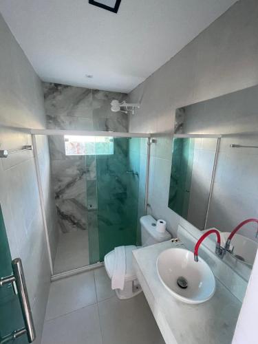 un bagno con lavandino, doccia e WC di FLAT MORRO Vista panorâmica 1praia a Cairu