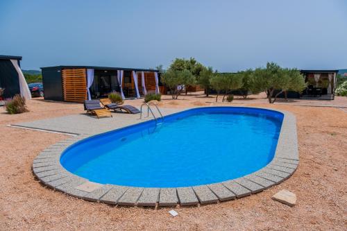 a large blue swimming pool in a yard at Mobile Homes Pirovac with 2 shared Pools in Pirovac