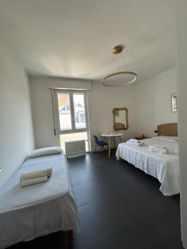 a room with two beds and a table and a mirror at M&M BERGAMO CENTER - Modern flat with FREE WIFI - Rent BIKE in Bergamo
