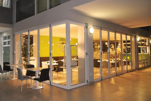 a dining room with a table and chairs and windows at Swakopmund Plaza Hotel in Swakopmund