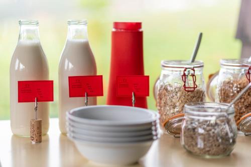 a table with bottles of milk and bowls of food at B&B Mont-Crosin in Mont-Crosin