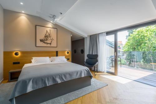 a bedroom with a large bed and a balcony at Hotel Squero in Rovinj