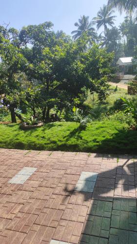 a shadow of a person walking on a brick sidewalk at CELESTIAL HOMESTAY in Pinangode