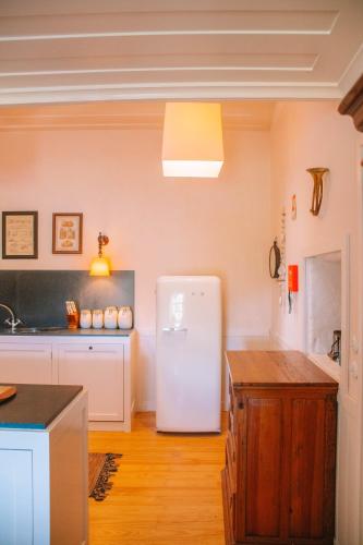 a kitchen with a white refrigerator in a room at Just Like Home - Casa do Cruzeiro in Moledo