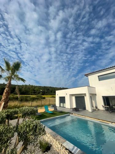 une maison avec une piscine devant une maison dans l'établissement Villa Sud La Cigale des Bois de Maruéjols, à Mons