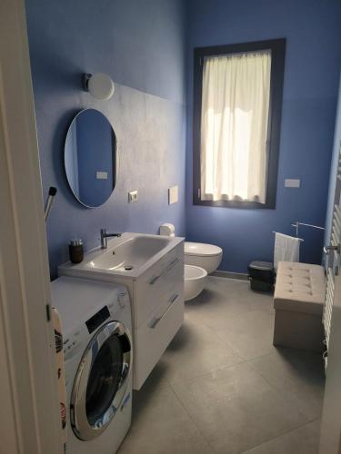 Un baño con lavadora y lavabo. en Rdm affittacamere, en Albiano