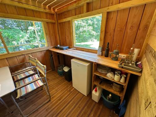 a kitchen with a sink and a refrigerator in a cabin at Cabane de Touraine au bord de l'eau in Candes-Saint-Martin