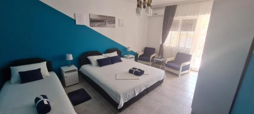 a bedroom with two beds and a blue wall at VuBra in Ulcinj