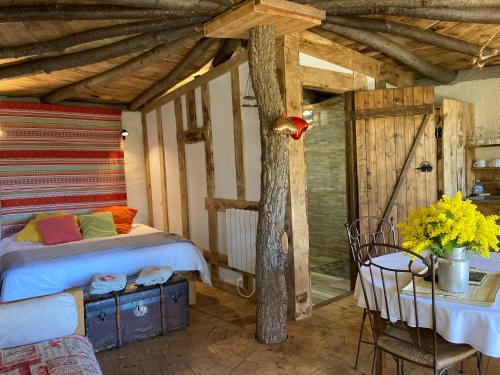 a bedroom with a bed and a table with a table sidx sidx sidx at Cabanes Trésors de Campagne,spas privatifs in Villarzel-du-Razès