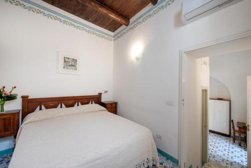 a white bedroom with a bed and a ceiling at Amalfi un po’... in Amalfi