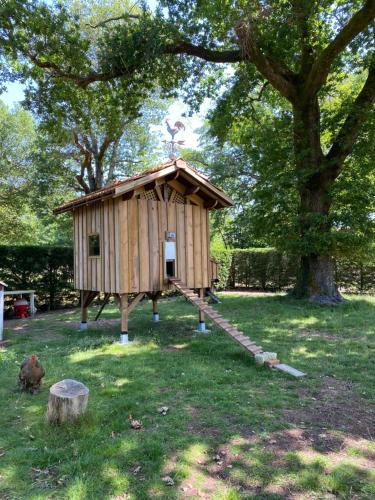 a small wooden play house in a park at Le chêne magique 40200 Margaux in Pontenx-les-Forges