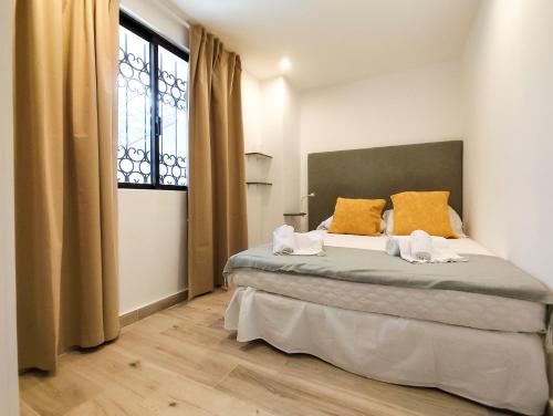 a bedroom with a bed with orange pillows and a window at Solar dos Pinheiros in Vilamoura